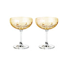 To orangefarvede facetslebne champagneskåle i krystalglas med diamantmønster fra Frederik Bagger