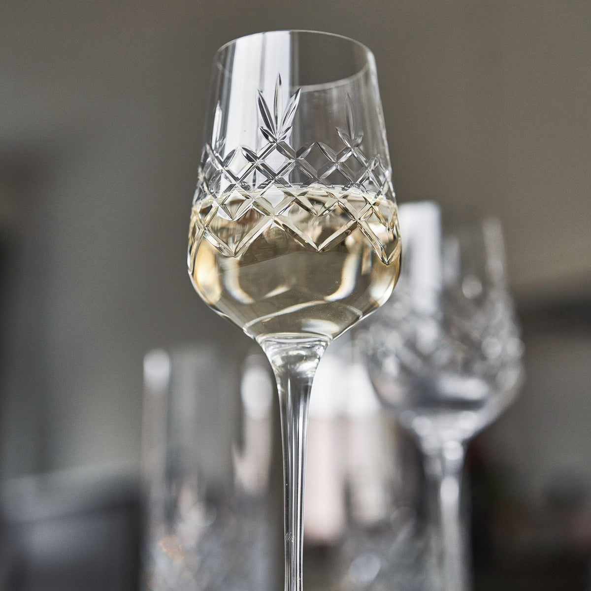 Krystalglas i klart glas med facetslebet diamantmønster fyldt med hvidvin fra Frederik Bagger, sæt á 4 stk.