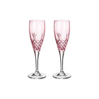 To pink facetslebne champagneglas med diamantmønster på klar stilk mod hvid baggrund