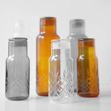 Fire facetslebne glasflasker i klar, citrine og røget glas med riflet diamantmønster til opbevaring fra Frederik Bagger
