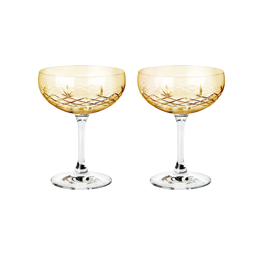 To orangefarvede facetslebne champagneskåle i krystalglas med diamantmønster fra Frederik Bagger