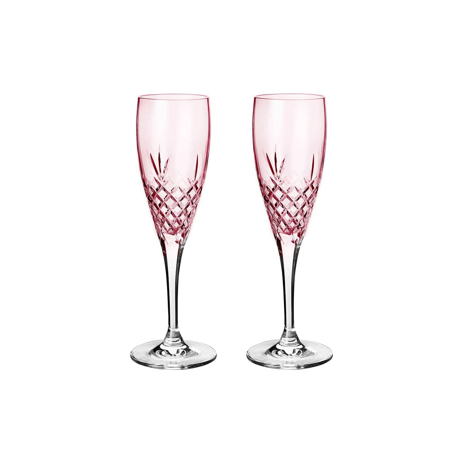 To pink facetslebne champagneglas med diamantmønster på klar stilk mod hvid baggrund